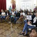 Alunos em círculo durante mediação. Uma delas segura placa dizendo com a palavra #pracegover 