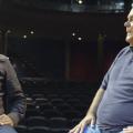 dois homens conversam lado a lado em palco. #paratodosverem
