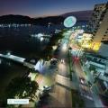 vista aérea da ponta da praia à noite, como o mar à esquerda, a avenida ao centro e os prédios à direito. Em primeiro plano, à esquerda, o deck do pescador. #paratodosverem