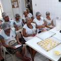 alunas assistem aula de panificação. pãezinhos crus estão sobre uma forma. #paratodosverem