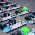 skates e capacetes dispostos no chão. #paratodosverem