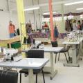 Foto de uma sala de costura com várias mesas. #paratodosverem