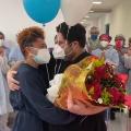 Homem com buque de rosas abraça namorada. Ao fundo vários enfermeiros tirando foto. #paratodosverem