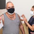 homem é vacinado no braço #paratodosverem