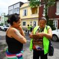 agente aborda mulher na rua com prancheta #pracegover 