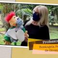 em  trecho do vídeo, professora segura fantoche, ambos de máscara #paratodosverem 
