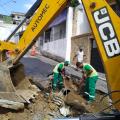 dois homens e máquina atuam em buraco na obra #paratodosverem