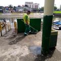 funcionário vestido de verde segura pincel grande de pintura #paratodosverem