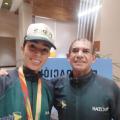 atleta com medalha e professor ao lado #paratodosverem