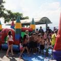 crianças em fila perto de um brinquedo colorido #paratodosverem
