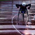 atleta na cadeira de rodas correndo um pista de atletismo molhada #paratodosverem