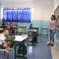 professora dá aula e crianças sentadas na sala #paratodosverem