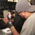 tatuador cria imagem em um homem que está deitado. #paratodosverem
