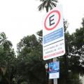 Placa de Zona Azul em poste metálico com árvores ao fundo. #pracegover