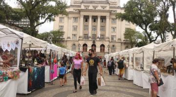 barracas montadas na praça mauá e pessoas circulando. Ao fundo, o palácio josé bonifácio. #paratodosverem