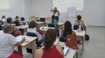 mulheres estão sentadas assistindo palestra. #paratodosverem