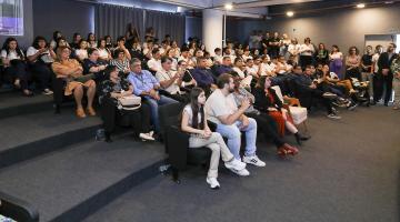 pessoas sentadas na platéia #paratodosverem