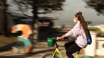 Mulher anda de bicicleta na ciclovia da orla de Santos. #paratodosverem