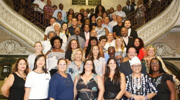 Diversas pessoas posam para foto em escadaria de hall da prefeitura. #Pracegover