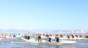 pessoas entrando com canoas havaianas no mar #paratodosverem