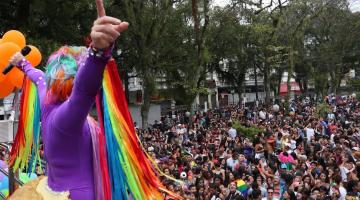 DRAG QUEEN DE COSTAS PARA A FOTO E DIANTE DE GRANDE PÚBLICO EM PRAÇA. #PARATODOSVEREM