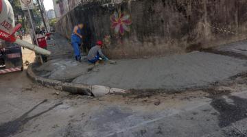 homens estão concretando calçada. #paratodosverem 