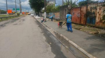 homens estão trabalhando no nivelamento de calçada em concreto. #paratodosverem