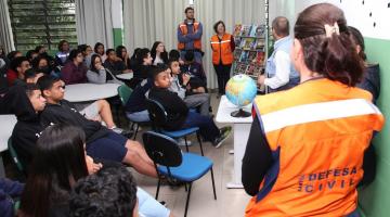 agentes da defesa civil estão em sala de aula com alunos. #paratodosverem