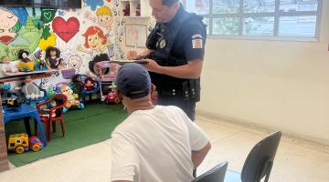 homem está sentado em sala do lado de guarda em pé. #paratodosverem