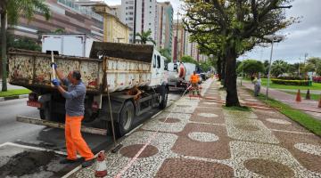 homens despejam detritos em caminhão estacionado na orla da praia. #paratodosverem 