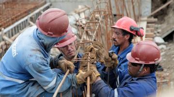 trabalhadores da construção civil estão montando estrutura de ferro. #paratodosverem