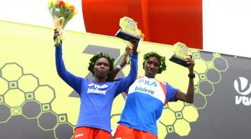 Viola Muneira Chemos e Marco Joseph erguem seus troféus. A mulher também segura um ramalhete de flores. #Pracegover