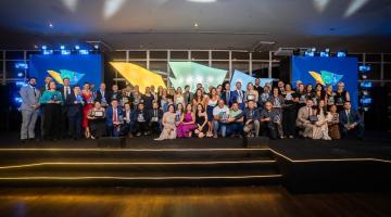 premiados posam para foto em palco. #paratodosverem