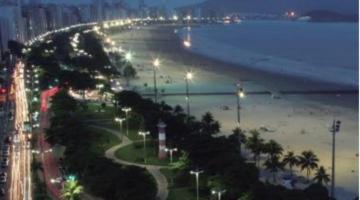 Capa do boletim com foto áerea noturna de Santos aparecendo jardins e praia #paratodosverem
