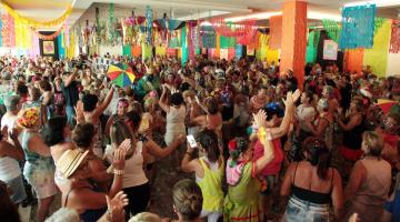 baile de carnaval com salão decorado e bárias pessoas dançando. #paratodosverem