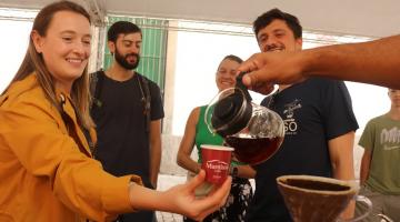 mão serve café para mulher em estande. #paratodosverem