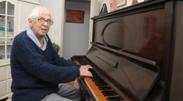 gilberto mendes posa para foto tocando ao piano. #paratodosverem