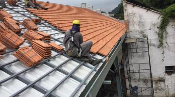 operário atua trocando telhas #paratodosverem 