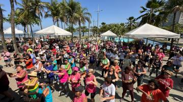 pessoas dançando na orla #paratodosverem 