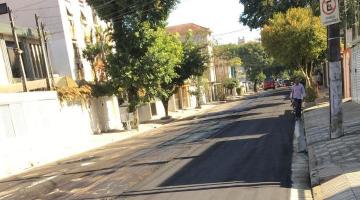 rua asfaltada com homem caminhando. #paratodosverem 
