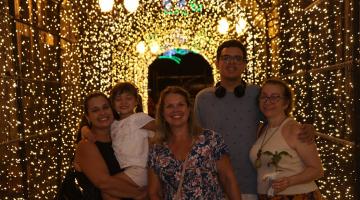 Família posa para foto em túnel iluminado #paratodosverem