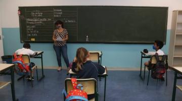 professora na sala de aula com alunos sentados na mesa #paratodosverem 