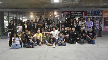 Jovens reunidos posam para foto em saguão. #paratodosverem