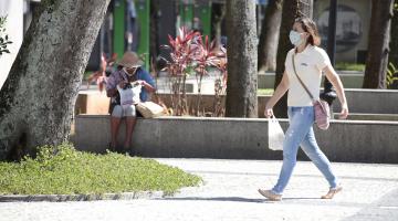 mulher anda de máscara com sacola #paratodosverem 