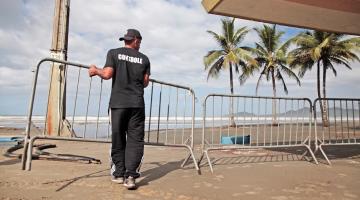 homem coloca cavalete para fechar a praia #paratodosverem 