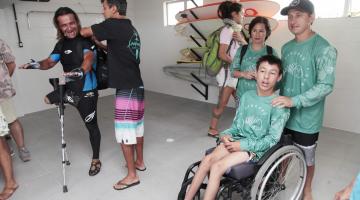 pessoas com deficiência visitam escola de surfe adaptado #pracegover 