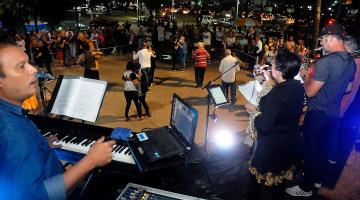 músicos tocando e pessoas dançando ao fundo #paratodosverem