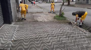 três homens estão capinando meio-fio e calçada. #paratodosverem