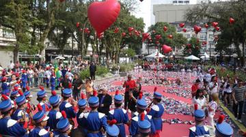 pessoas na praça ao redor dos corações #paratodosverem