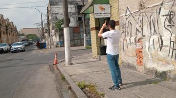 homem fotografa fios em poste., #paratodosverem 